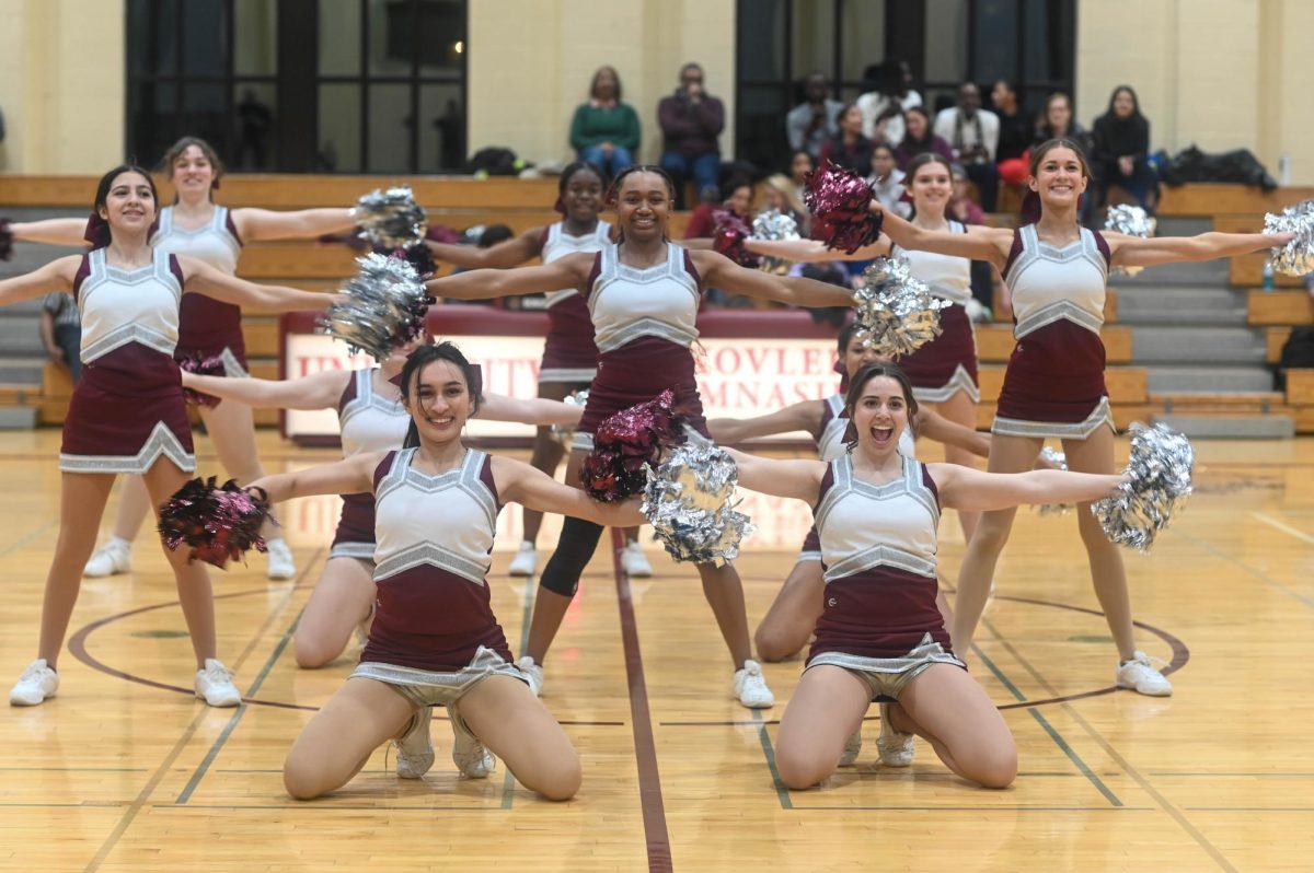 Sonali Shaw and Ceci Siegel pose in the front row at the end of the team's dance during the halftime of a basketball game on Feb. 7. 