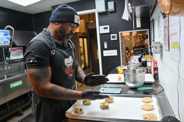 Dressed head to toe in his own merchandise, Quinton McNair, founder and owner of StruggleBeard Bakery, prepares a batch of his lemon cookies. With his background of battling struggles and determination to grow a beard, Mr. McNair started this buisness to give back to his community through sweet treats.