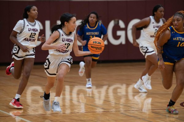 Senior Alex Giles dribbles the ball up the court during the varsity girls basketball game against DeLaSalle on Dec. 5. The team ended its season on Feb. 15 in the first round of regionals, losing 13-38 to Dyett High School. 