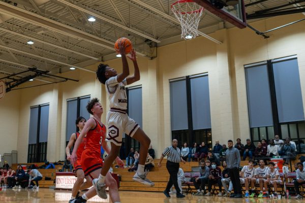 Senior Noah Runesha lays the ball up during the varsity boys basketball game against Latin on Jan. 17. The team ended its season on Feb. 26 with a 57-41 regional semifinal loss to top-seeded Leo High School.