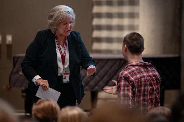 Senior Miles Wilczak assists Susan Groesbeck as she steps offstage at the back-to-school assembly on Sept. 3.  Dr. Groesbeck brings decades of experience in leadership and education to Lab.