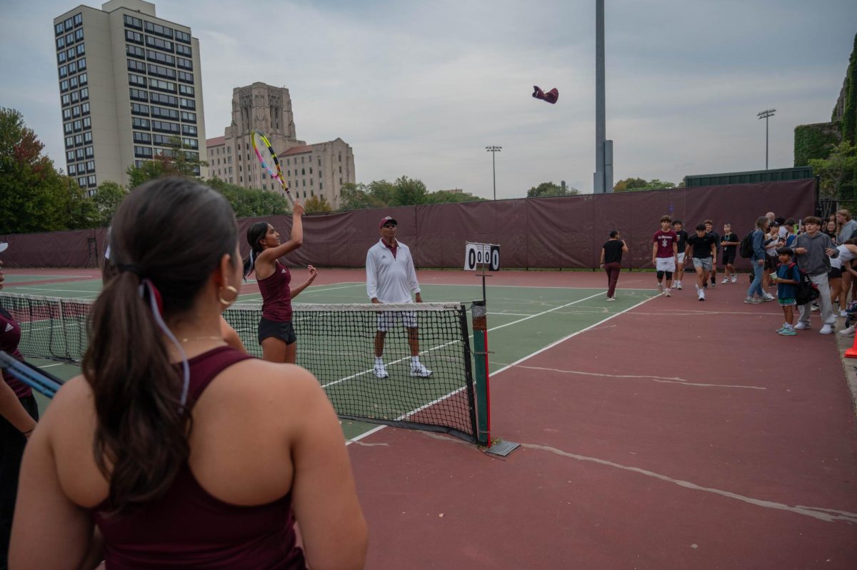 SHIRT SERVE. Ninth grader Anika Sadanand hits T-shirts into the crowd following the match against Lake Forest Academy at the U-High tennis courts on Sept. 19. U-High lost the match 2-3.