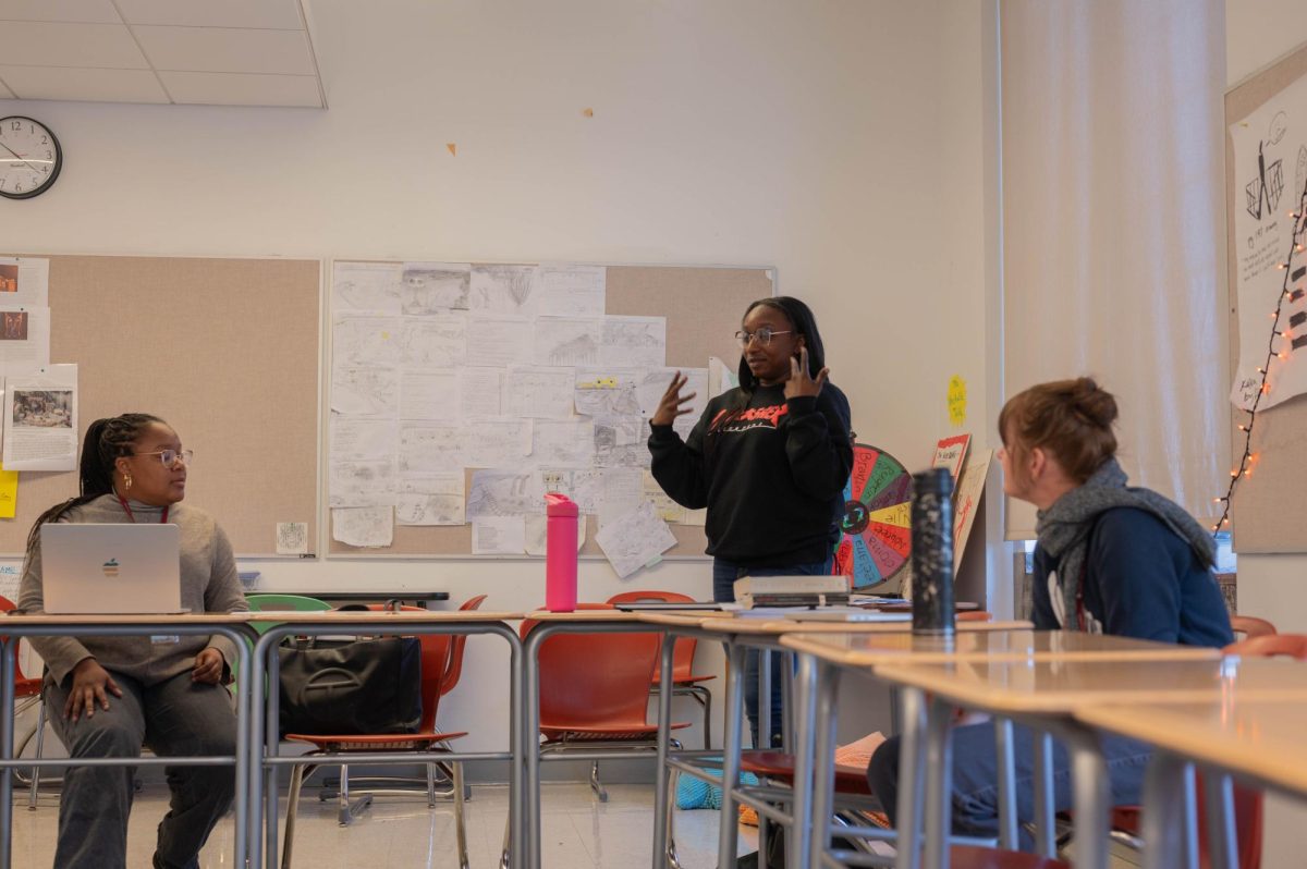 In a meeting between English 1 teachers, Arney Bray stands up and addresses fellow English teachers. The Lab review was released and is currently available online. One part of the review talked about curricular autonomy and standardizing class expectations.