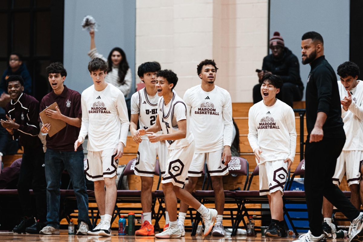 Courtside Cloud Nine. The boys varsity basketball team celebrates a win after a close game against North Shore Country Day on Jan. 9 in Upper Kovler. Sophomore Anik Jeffrey was among those rejoicing. “That game was intense because we were down for a lot of it,” he said. Photo by Bryce Kenny