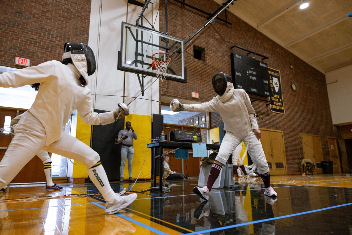 Heading for the Hit. In a varsity open competition on Nov. 22, ninth grader Amy Zhao faces off against a fencer from Stevenson High School at the GL South Duals at Marian Catholic High School in Chicago Heights, where Marian beat U-High twice. Photo by Noah Gunning