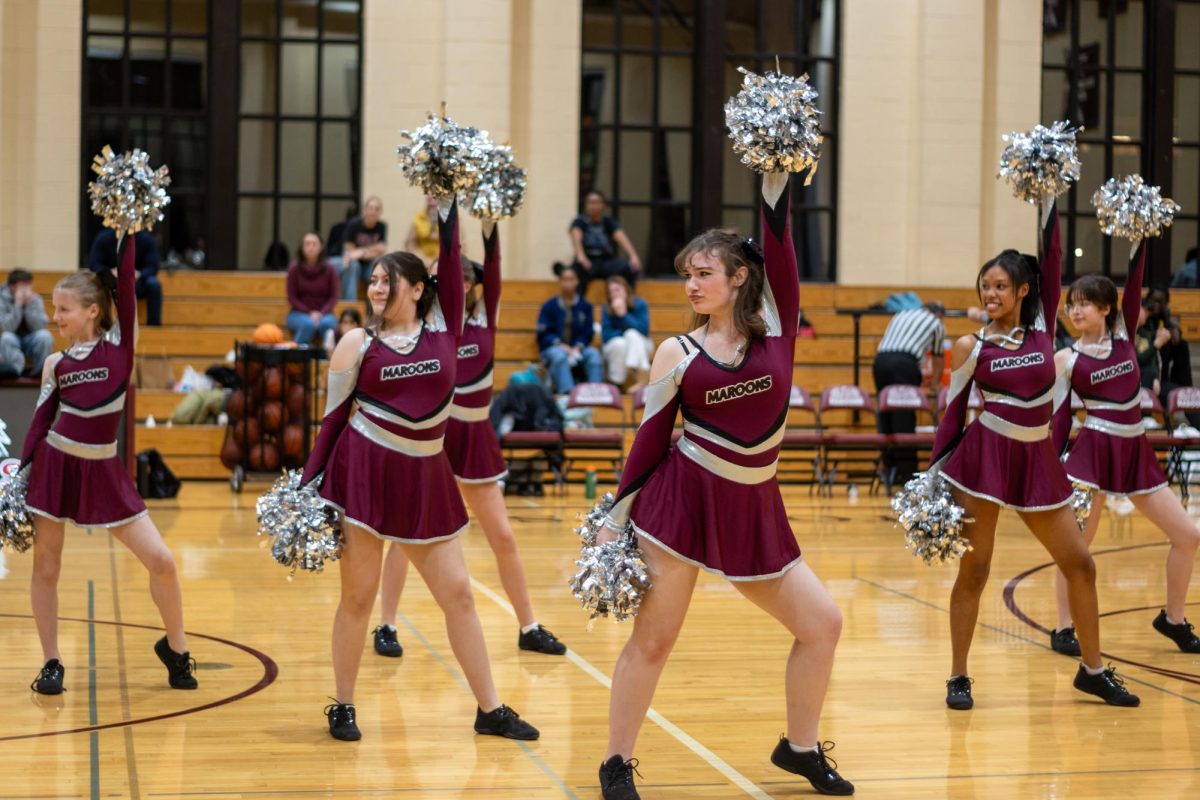 Halftime Heat. Senior Capri Cooper and dance team members perform in formation at halftime of the girls varsity basketball game on Dec. 18 against Richards High School in Upper Kovler Gymnasium. The competition dance team recently qualified for the IDTA State Championships in both the hip hop and pom categories. Photo by Asha Reynolds-Stewart