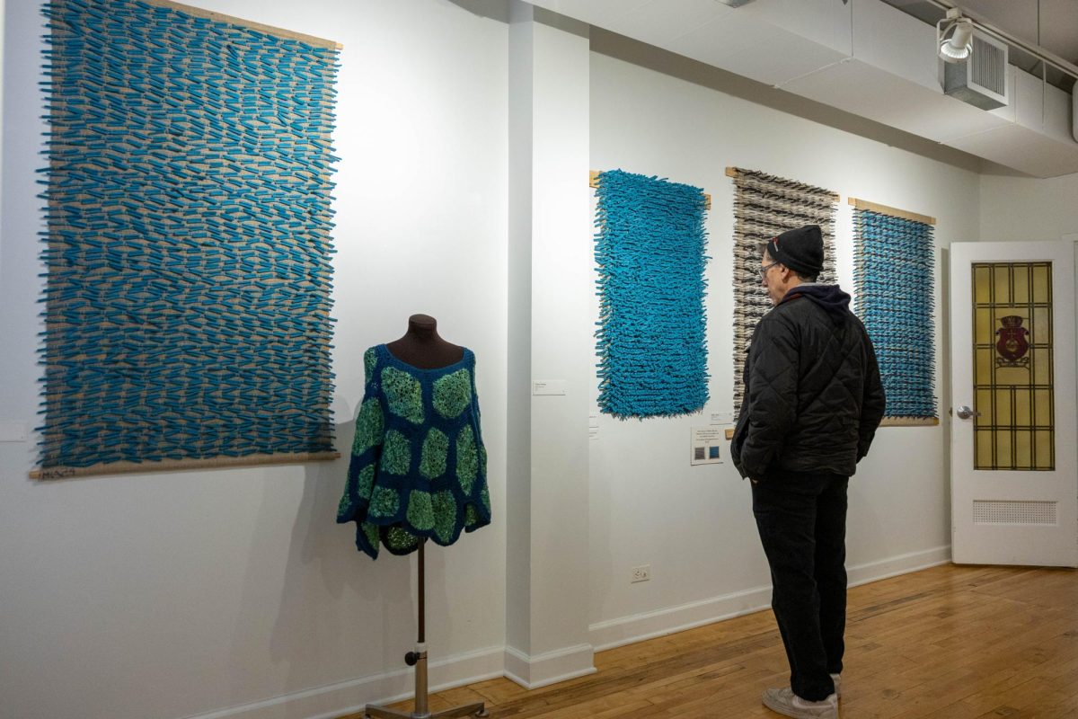 At the Swedish American Museum in Andersonville, a neighborhood known for its Swedish history, a museum patron views a postmodern rya rug, a style of Scandinavian-inspired rug that reinterprets traditional, hand-knotted rya techniques through a modern, often unconventional lens.