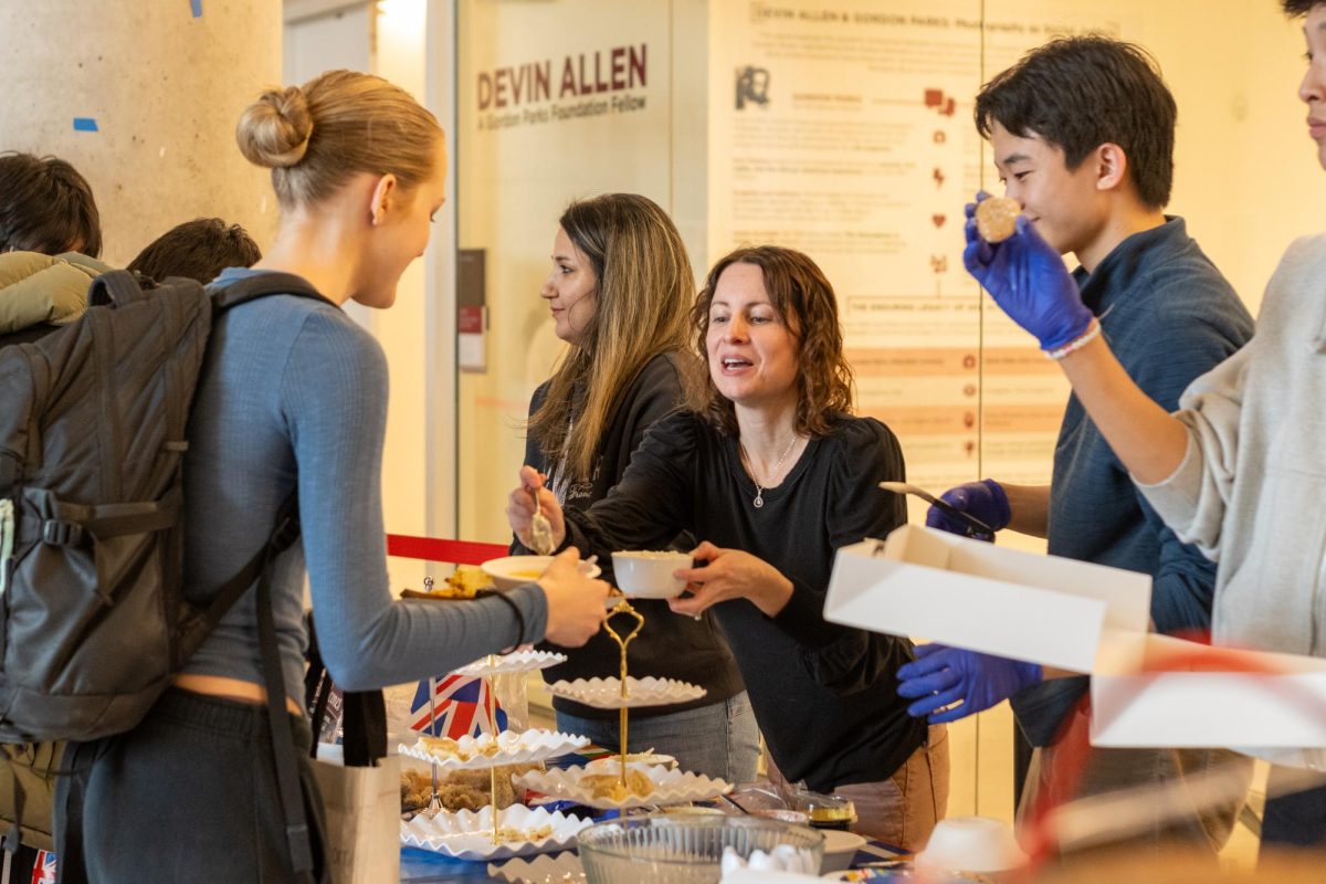 BRITISH BITES. On Feb. 11, junior Celia Lukas is served a sauce to accompany traditional English scones by Farah Adhi, a parent volunteer. "I really liked the chance to try a bunch of different foods from a bunch of different places," Celia said. Photo by Asha Reynolds-Stewart.