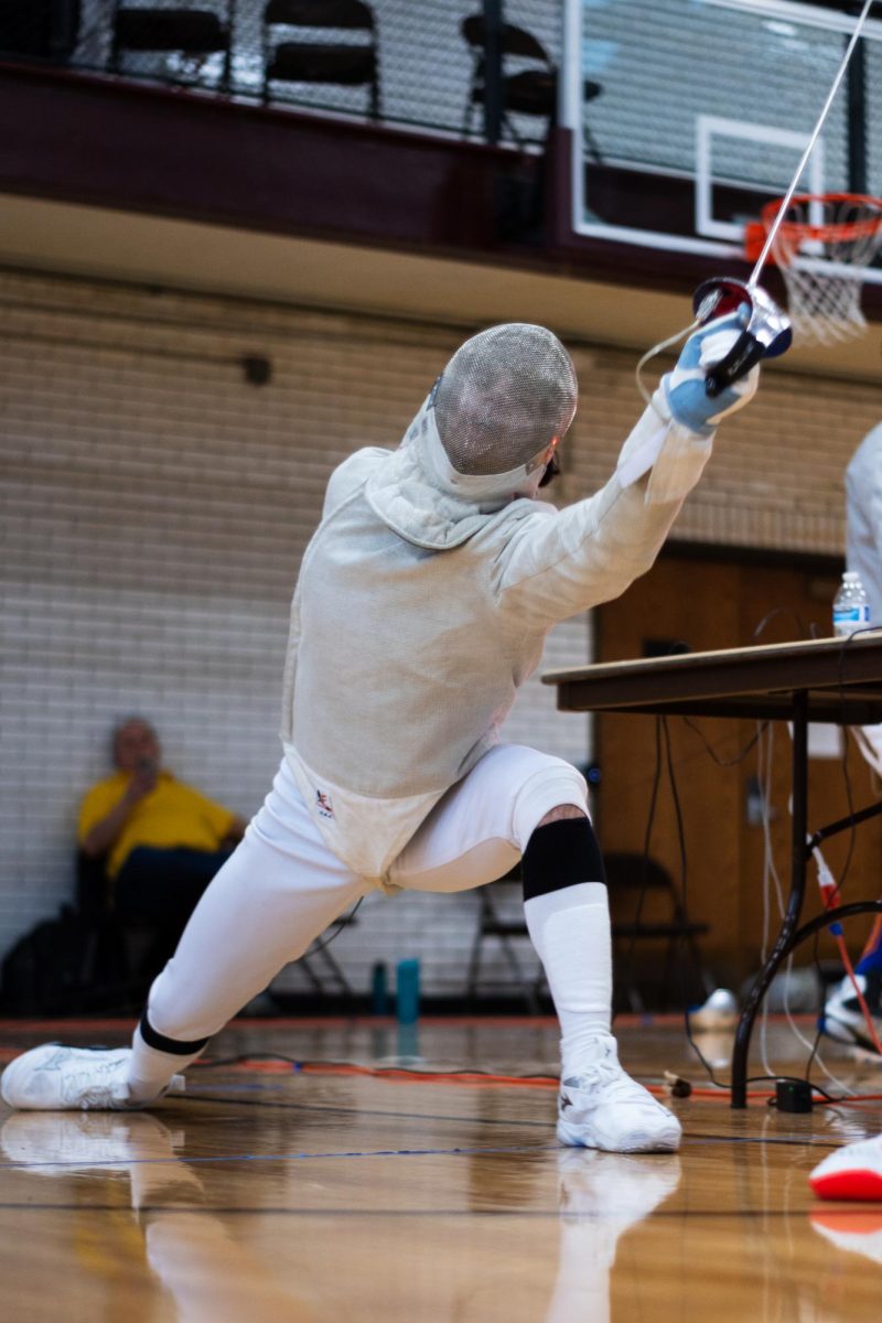 At a fencing tournament on Dec. 13, sophomore Sacha Twemlow lunges for a hit.