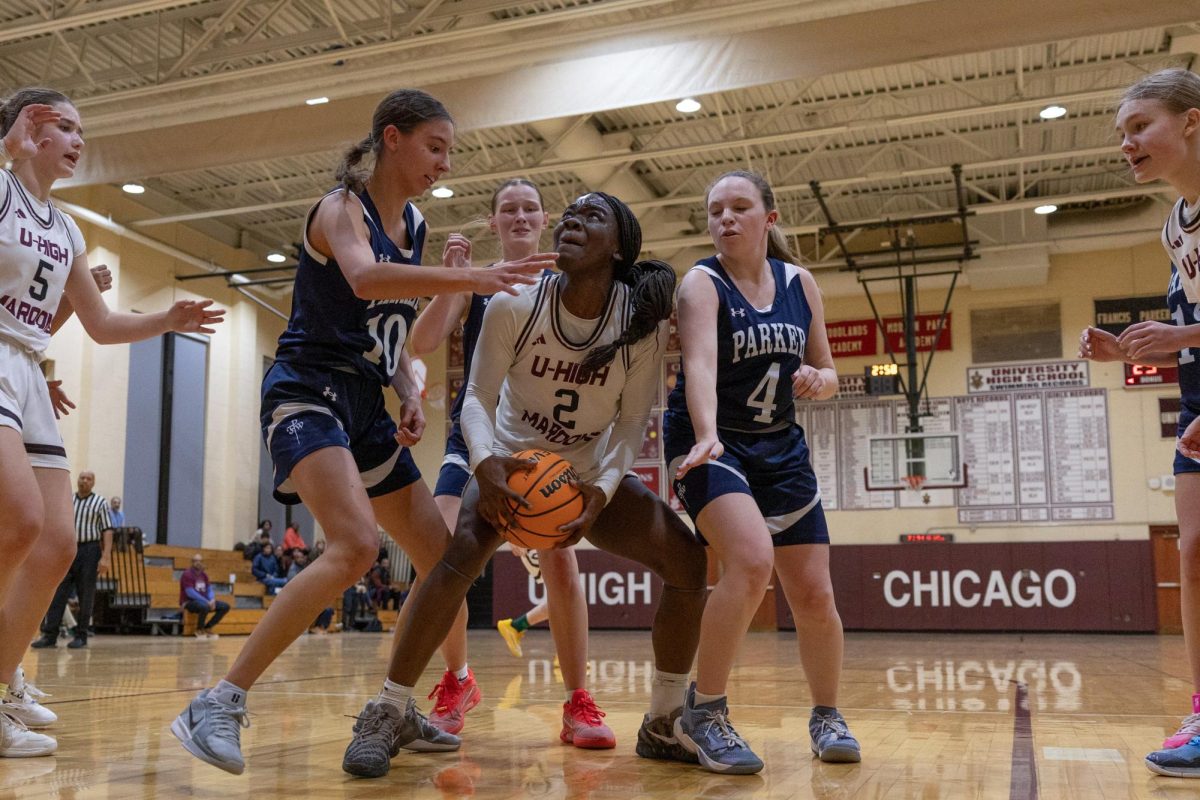 Fighting for the ball, girls basketball team captain Nanak Ofori-Mante, a junior, plays in a game against Francis W. Parker School on Feb. 10.