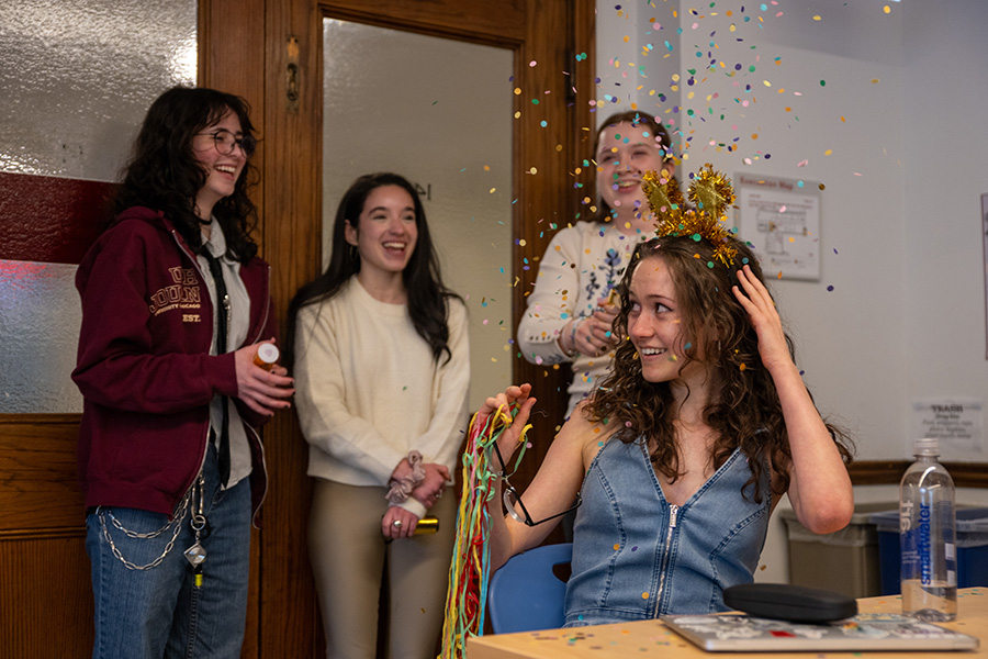 GUIDING LIGHT. Confetti falls over Light Dohrn as she celebrates her Illinois Journalist of the Year award with fellow journalism students Lucy Byrnes, Lila Coyne and Elspeth LaCroix-Birdthistle. During her sixth period class, Light was surprised with a small celebration of her winning Illinois Student Journalist of the Year, including her friends, parents and classmates. 