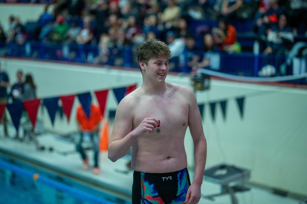 At IHSA varsity sectionals on Feb. 21, senior Sam Oyler smiles on the pool deck posing with his medal. During the meet, Sam competed in the 200 medley relay with Henry Lyon, Christian Banini and Ari Wong coming in 4th place, and later competed in the 100 backstroke placing 2nd.