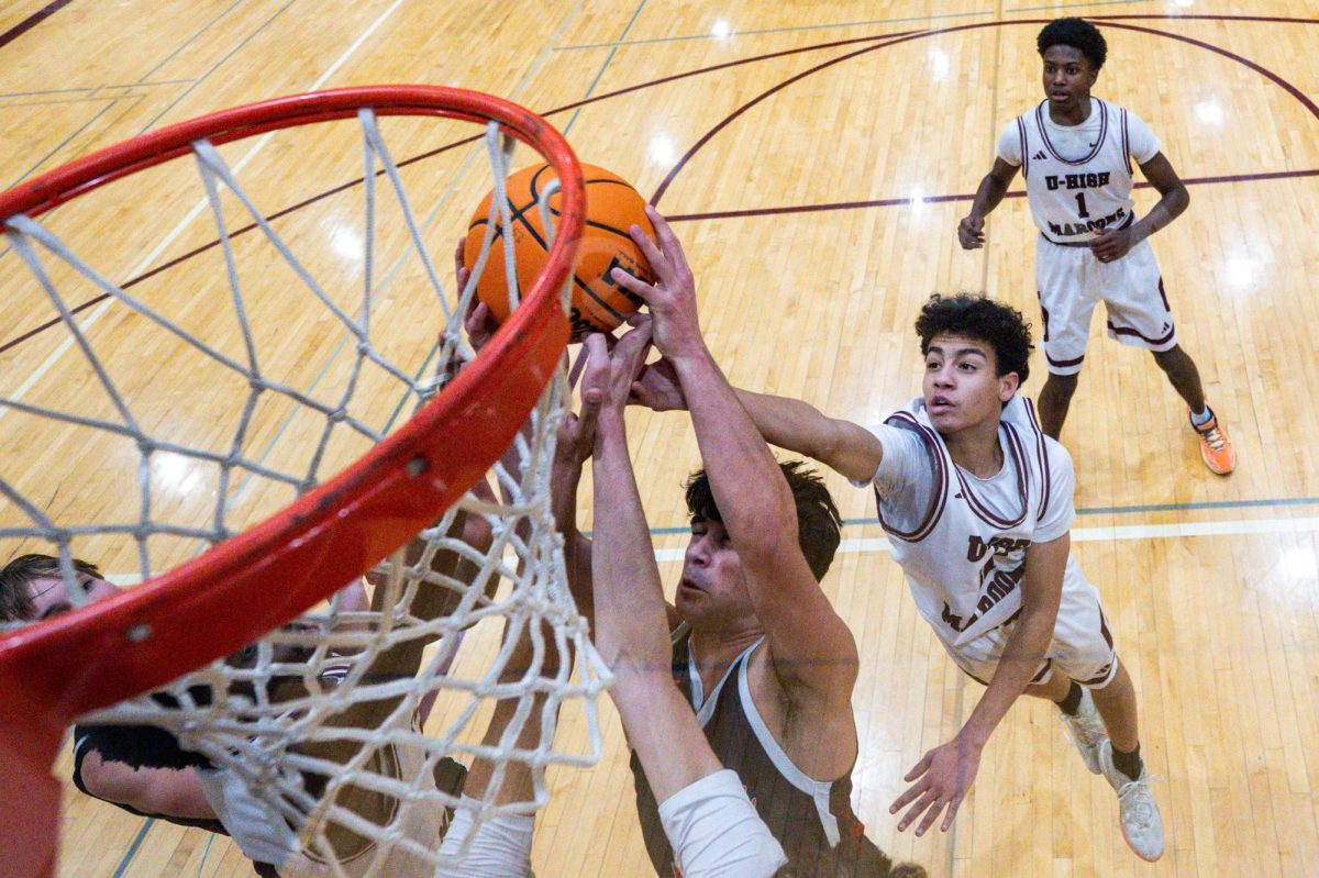 Sophomore Anik Jeffrey blocks a layup from the Latin team during a Feb. 4 game. 
