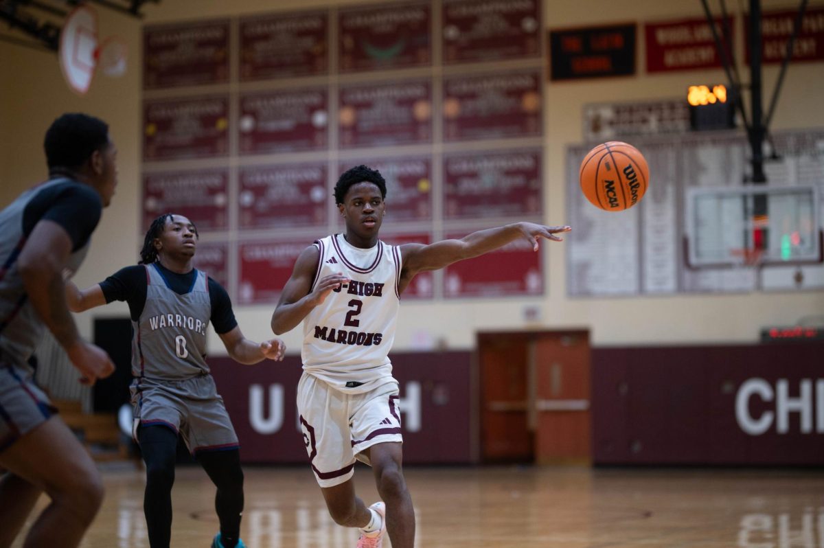 During the senior night game against Woodlawn, junior Bomi Johnson finds his way around two defenders to pass to a teammate.