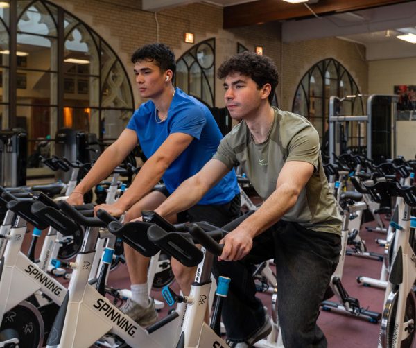 Seniors Cyrus Black and Alex Diamond train in the fitness center for their upcoming triathlon in Oahu, Hawaii, on May 17. Training has forced Cyrus and Alex to think carefully about their habits.