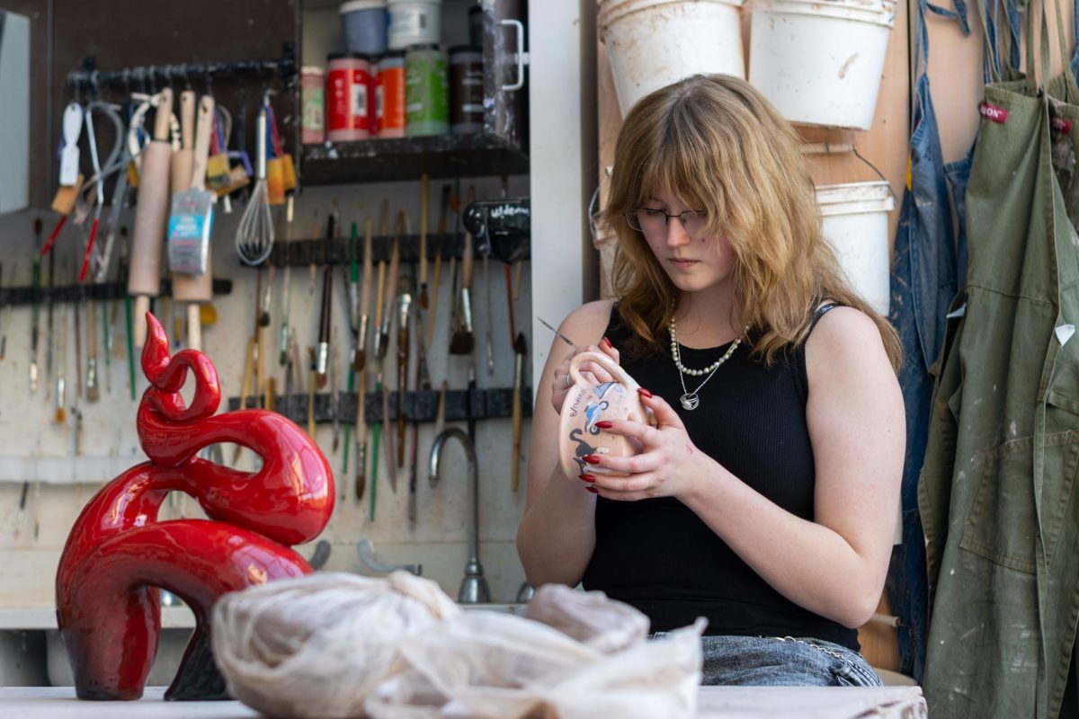 Senior Liz Longnecker puts the final touches on a cat-themed mug. On April 19, Liz won best in show for her sculpture piece at the Northern Illinois Regional Art Exhibition. Several other students also received scholarships.