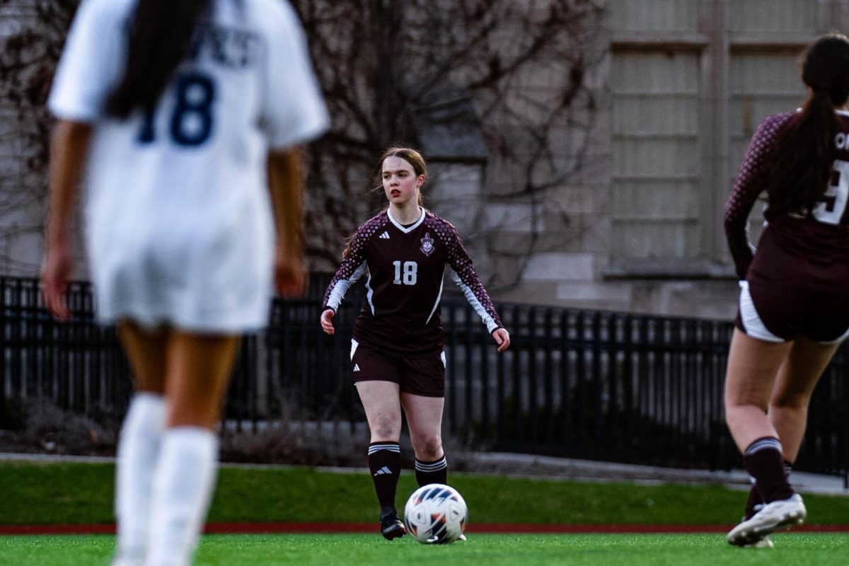 In the April 7 game against Acero Soto High School, senior Isolde LaCroix-Birdthistle controls the ball as she sets up for a pass. The game ended in a decisive 8-0 win for the Maroons. 