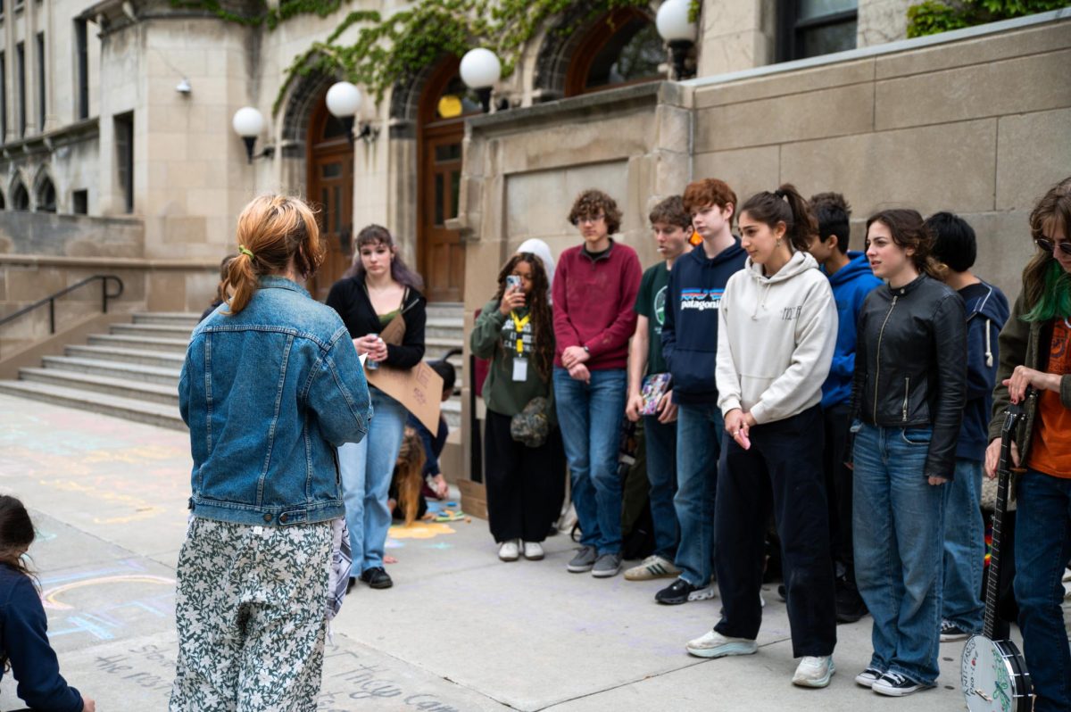 Junior Clara Golley addresses the crowd of protestors at the student-led May Day protests on May 1. The protest involved various activities such as chalk drawing, sign holding and music performance. 
