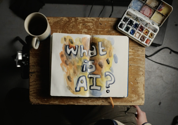 Painted Possibilities: A notebook displaying the question “What is AI?” sits beside watercolor paints as “The AI Doc: Or How I Became an Apocaloptimist” examines society’s mixed emotions surrounding artificial intelligence. Directed by Daniel Roher and released in March 2026, the documentary discussed the rapid growth of AI technology and the concerns tied to its influence on humanity’s future. “There are an insane number of challenges ahead of us but if we can get past them, we can unlock a future beyond our wildest imagination,” one interviewee said in the film.