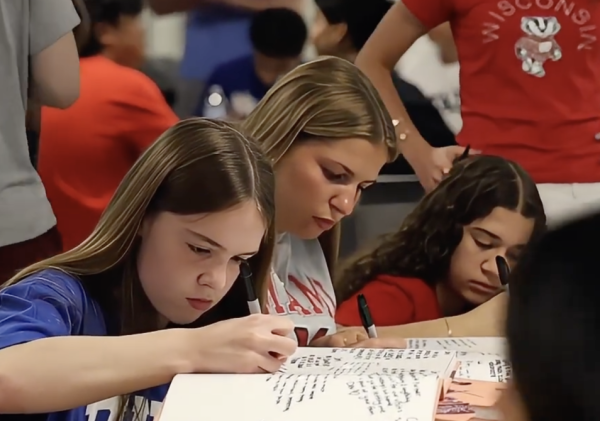 SENIOR SEND-OFF. On June 4, seniors saw their 2026 U-Highlights yearbooks for the first time in Café Lab at the senior breakfast. Before the awards assembly, they had the chance to sign each other's books.